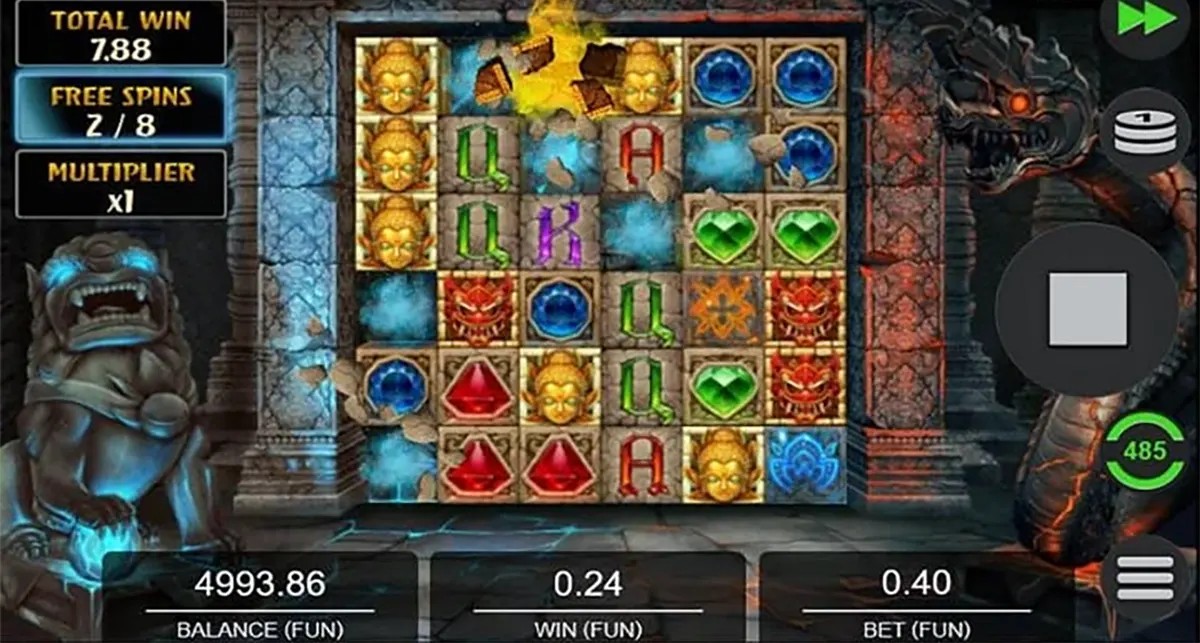 “Temple Tumble Megaways free spins gameplay screen with a stone-tile reel grid showing golden Buddha faces, coloured gems and letters, plus a left sidebar displaying total win, free spins (2/8) and multiplier, and balance/win/bet values along the bottom.”