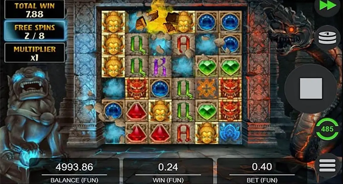 “Temple Tumble Megaways free spins gameplay screen with a stone-tile reel grid showing golden Buddha faces, coloured gems and letters, plus a left sidebar displaying total win, free spins (2/8) and multiplier, and balance/win/bet values along the bottom.”